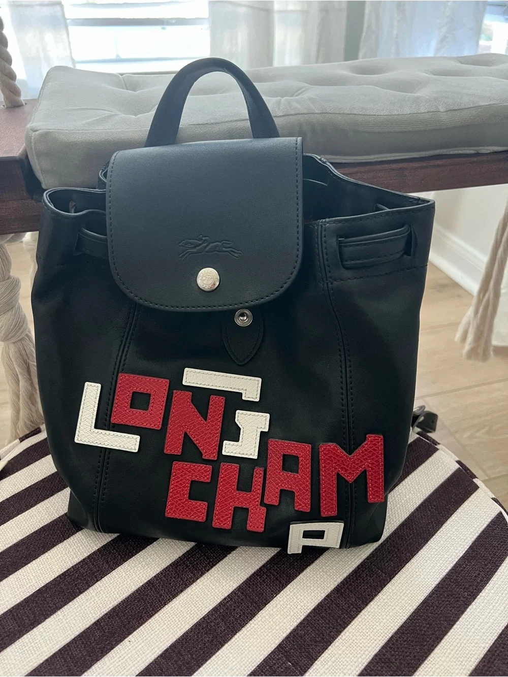 Longchamp Black Backpack with Red and White Lettering Appliqué